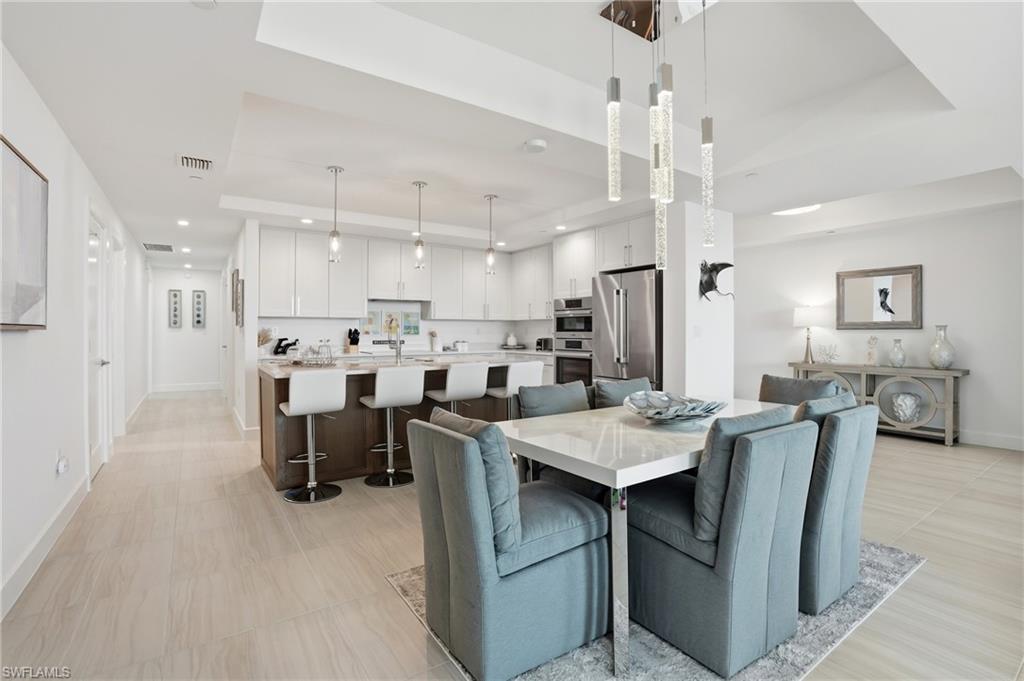 Dining area with a raised ceiling and recessed lighting - Virtually Edited Image