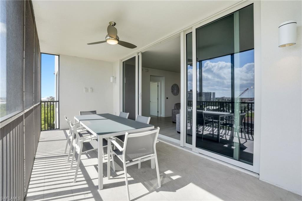 Balcony featuring outdoor dining area and a ceiling fan - Virtually Edited Image