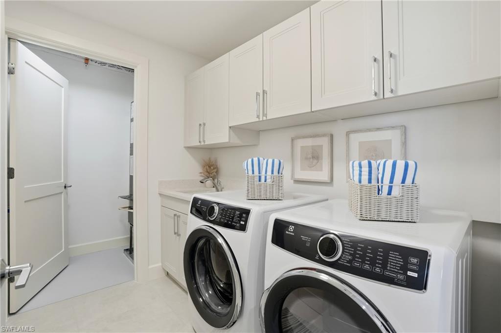 Washroom with washer and dryer, cabinet space, and light tile patterned floors - Virtually Edited Image