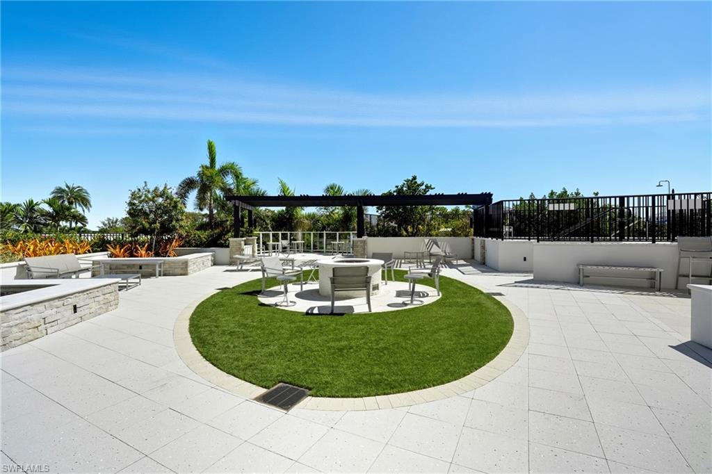 outdoor area near hot tub featuring a fire pit and a patio area- Virtually Edited