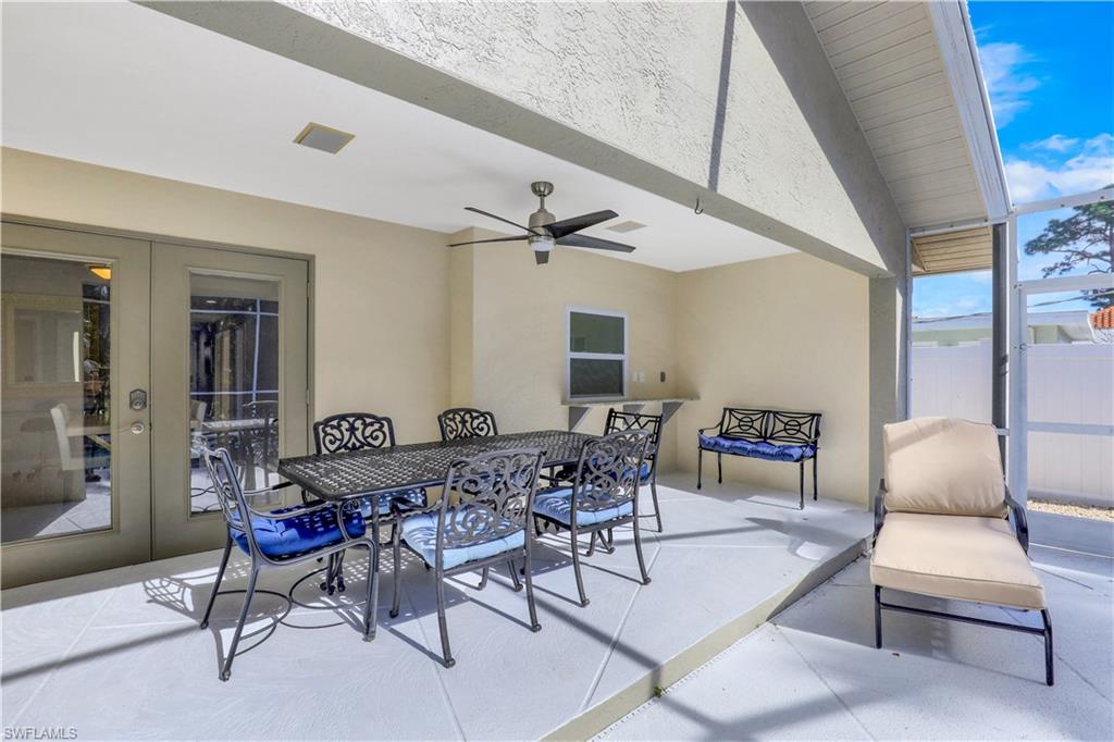 View of patio featuring outdoor dining space, french doors, a ceiling fan, and a sunroom