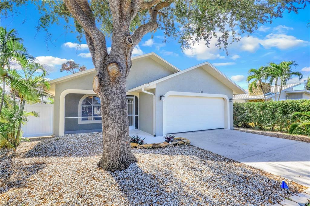View of front of house featuring an attached garage, stucco siding, and driveway