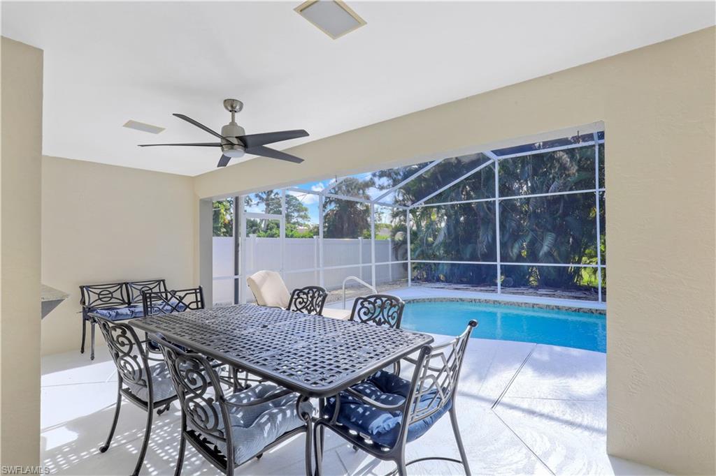 View of patio / terrace featuring outdoor dining area, a lanai, a sunroom, an outdoor pool, and a ceiling fan