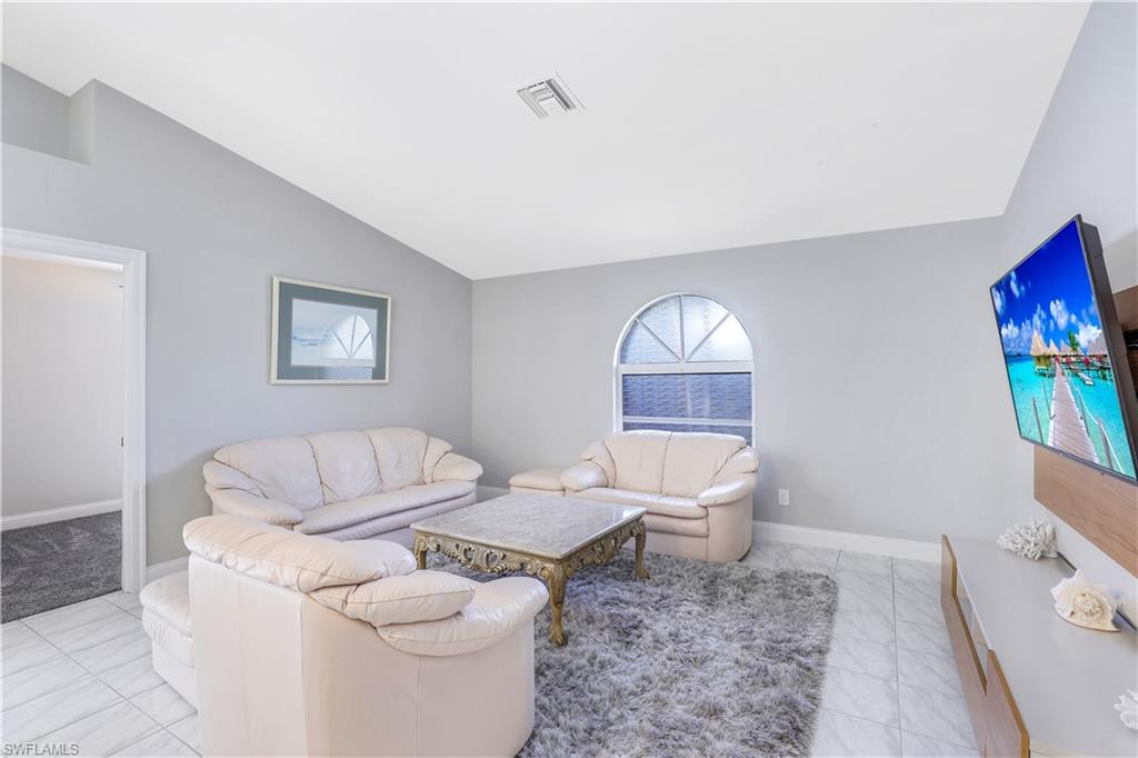 Living room featuring lofted ceiling and baseboards