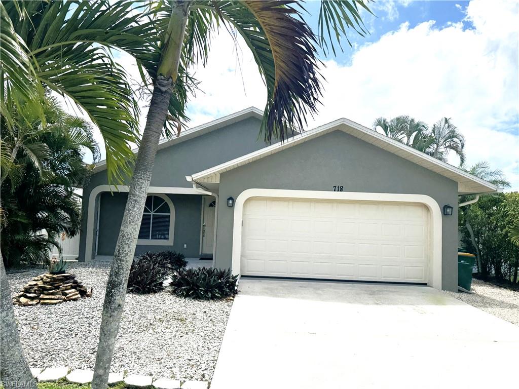 Single story home with an attached garage, stucco siding, and concrete driveway