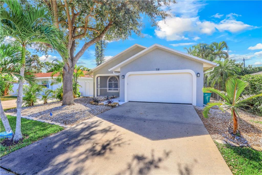 Single story home with a garage, stucco siding, and driveway