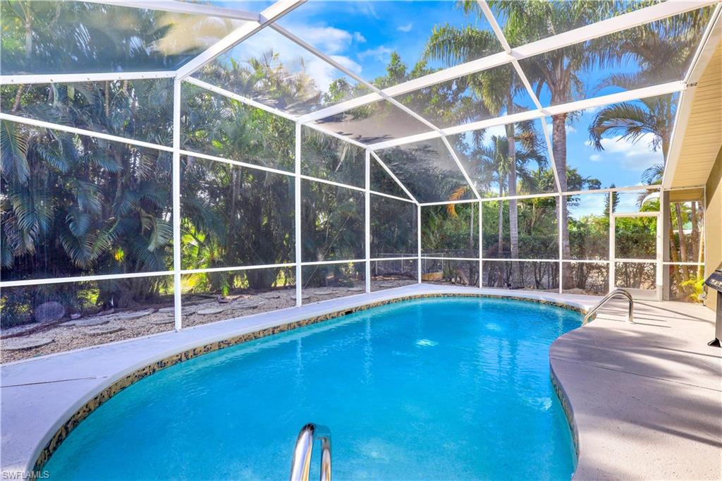 Swimming pool with a lanai, a sunroom, and a patio area