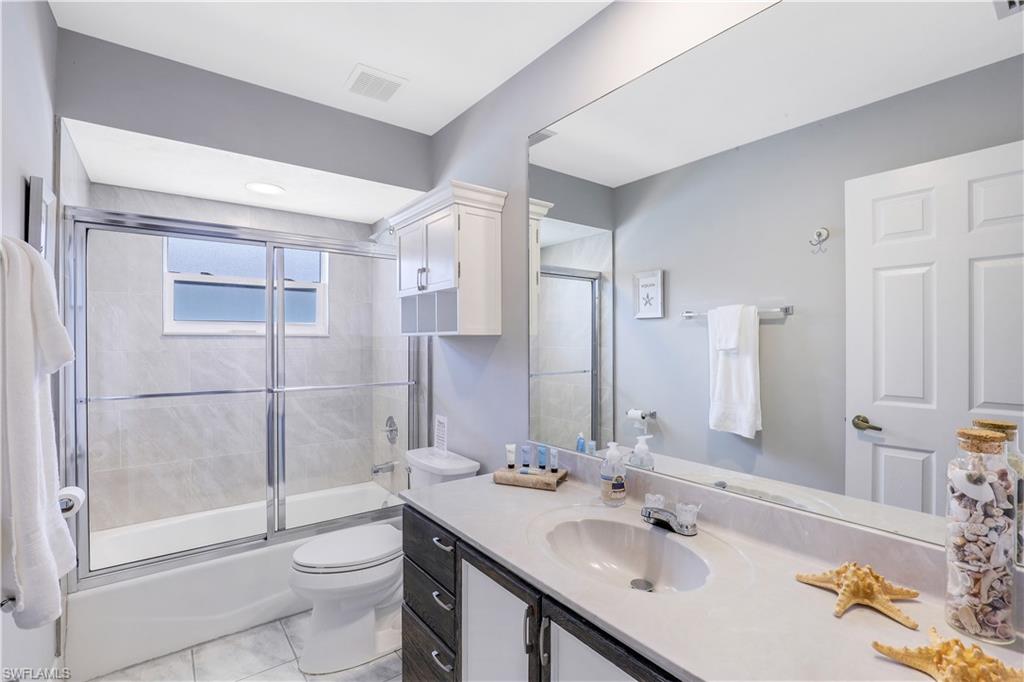 Full bath with vanity and combined bath / shower with glass door