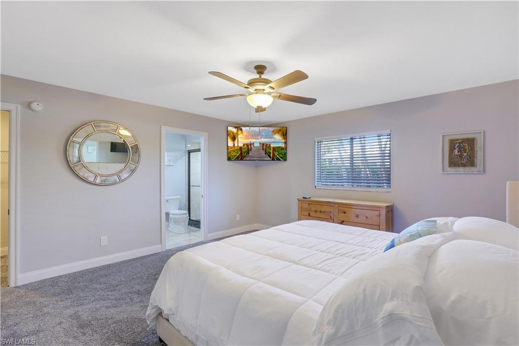 Carpeted bedroom with a ceiling fan and ensuite bathroom