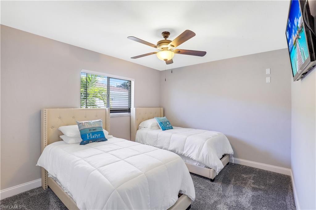 Bedroom with a ceiling fan and dark carpet
