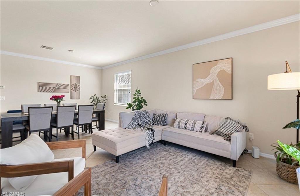 Living room with ornamental molding and light tile patterned flooring