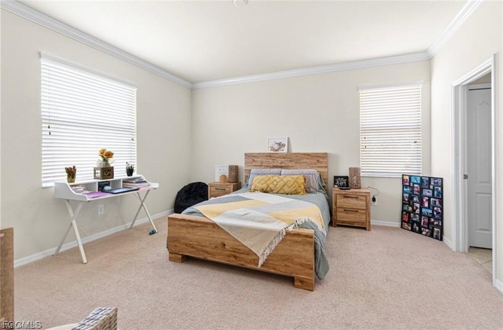 Bedroom featuring light colored carpet and ornamental molding