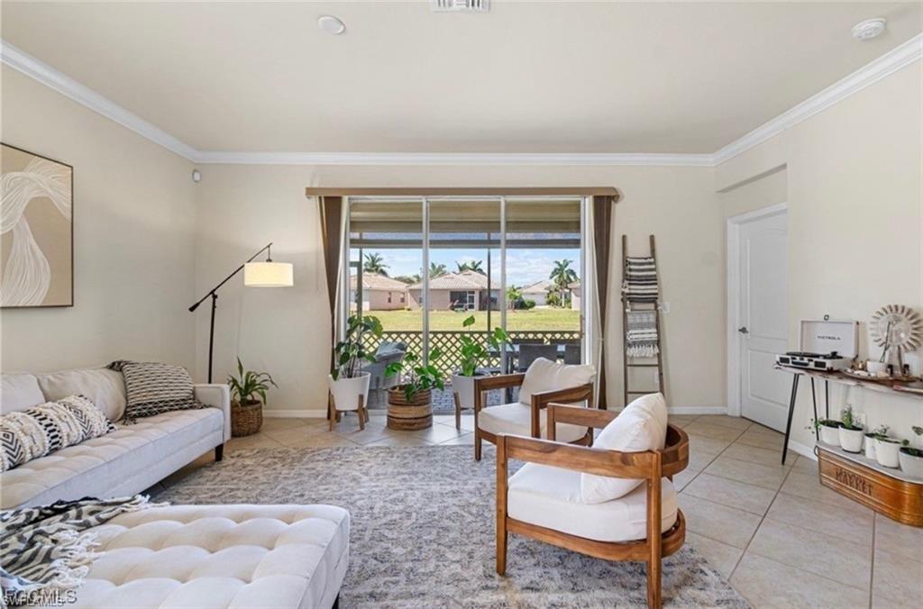 Living area featuring light tile patterned flooring and crown molding