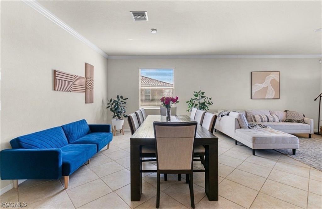 Dining area featuring crown molding and light tile patterned floors