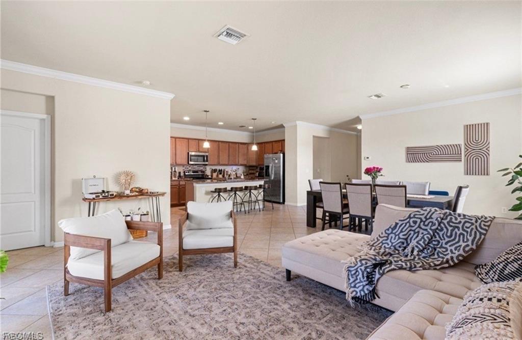 Living area featuring ornamental molding, light tile patterned floors, and recessed lighting