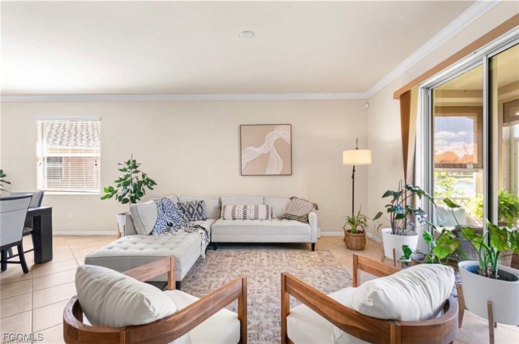 Living room featuring light tile patterned flooring and crown molding