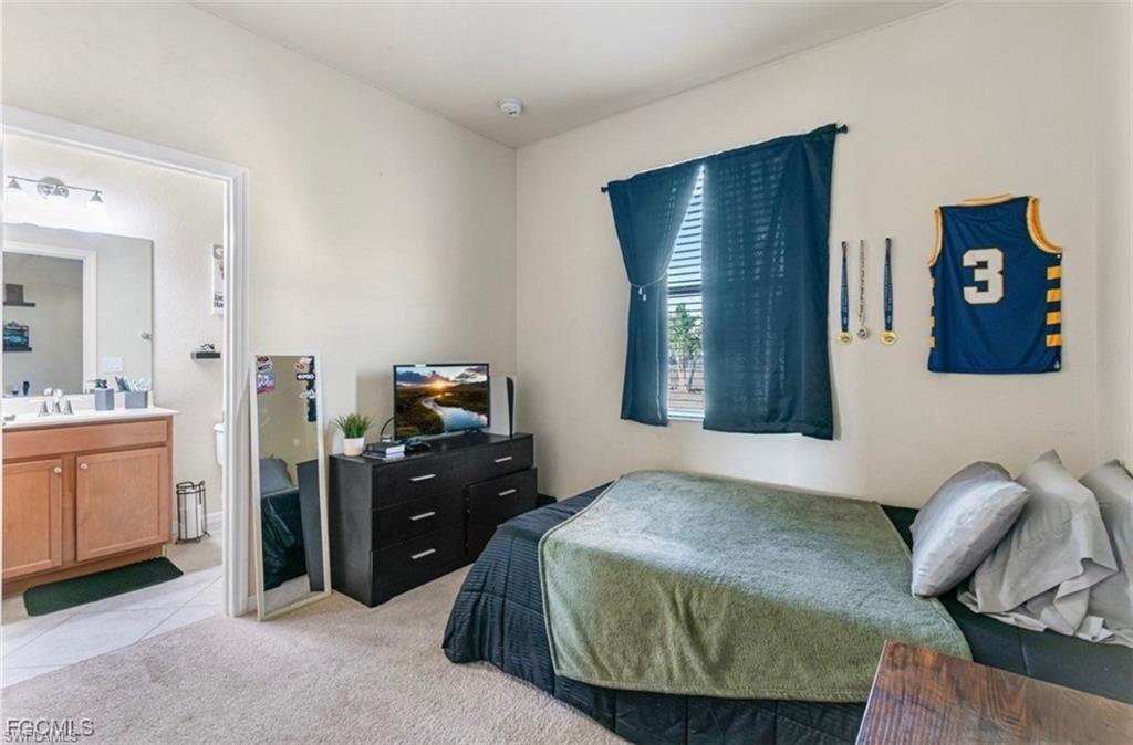Bedroom with light colored carpet and ensuite bathroom