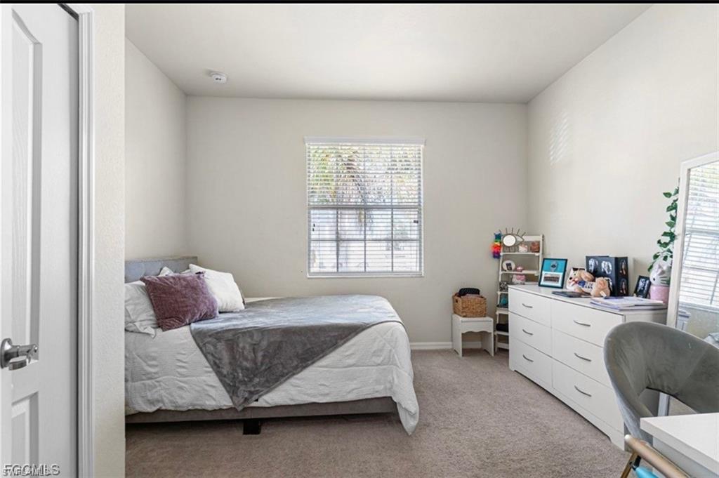 Bedroom featuring light carpet and baseboards