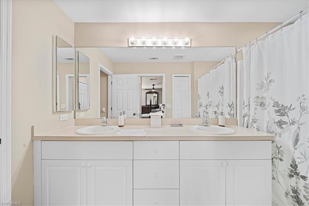 Bathroom featuring double vanity and curtained shower
