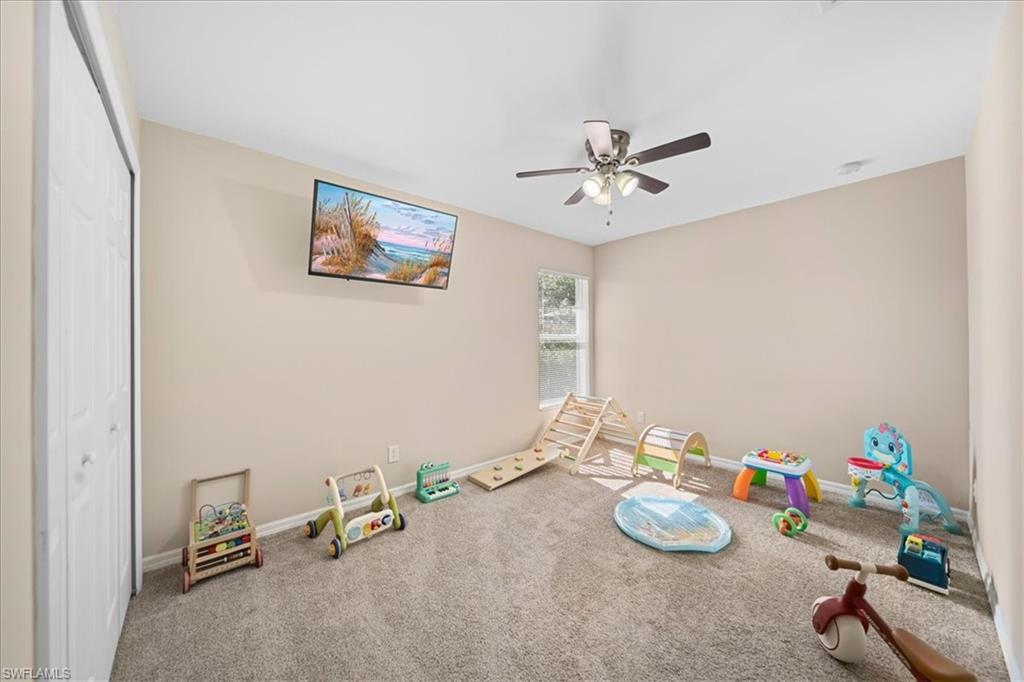 Rec room featuring a ceiling fan and carpet flooring