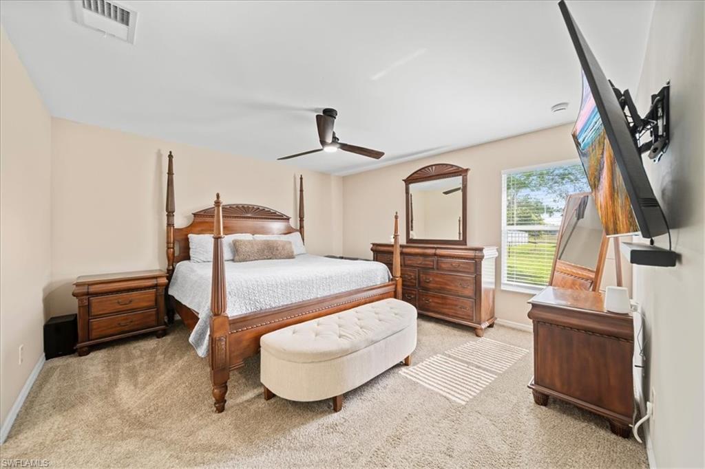 Bedroom featuring a ceiling fan and light colored carpet