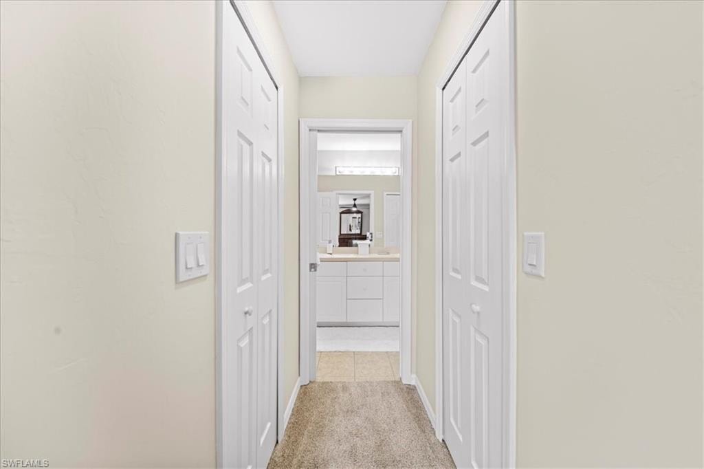 Hall featuring light colored carpet and baseboards
