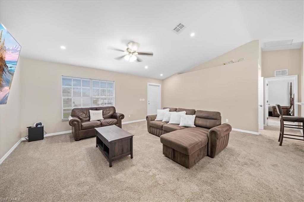 Living room featuring ceiling fan, light carpet, and recessed lighting