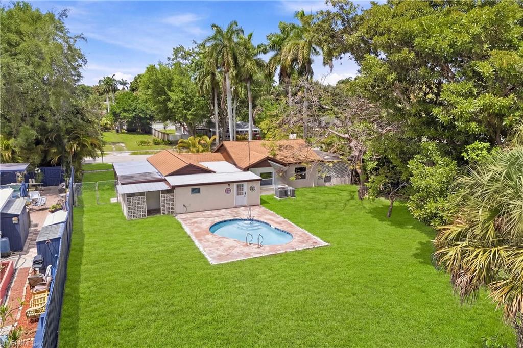 Beautiful overhead view highlighting the pool surrounded by landscaped grounds and open backyard space.