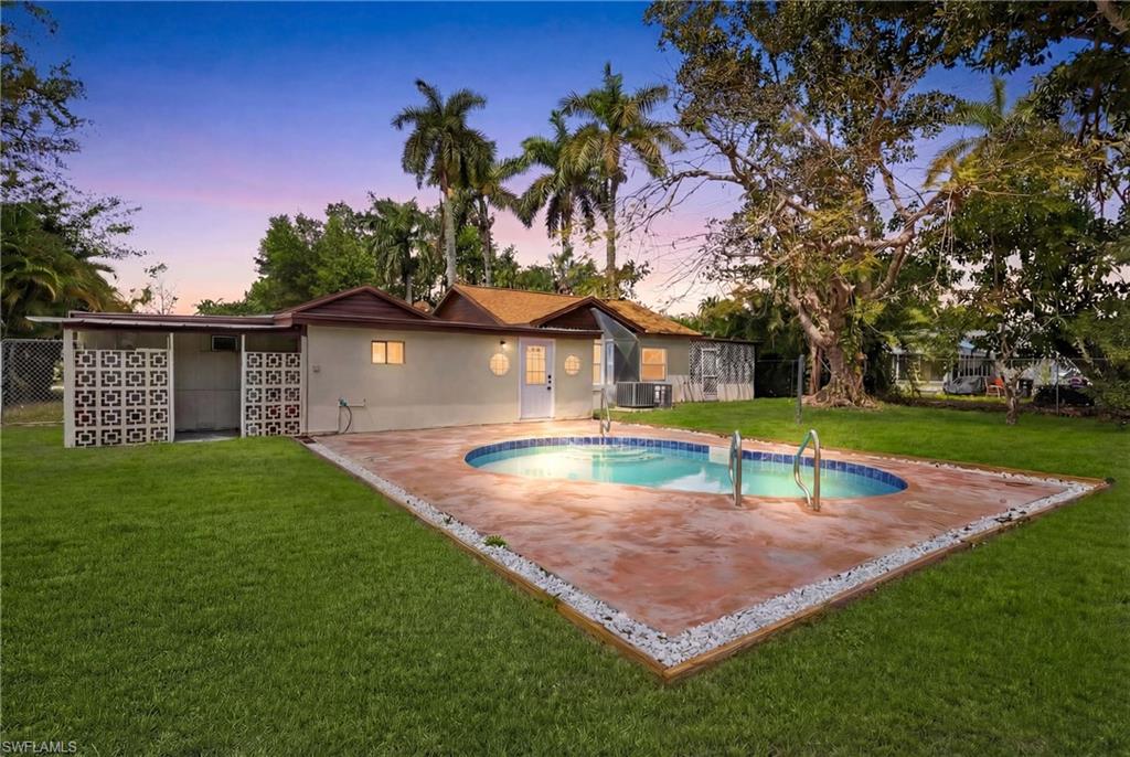 Stunning view showcasing the pool, landscaped backyard, and warm sunset glow over the property.