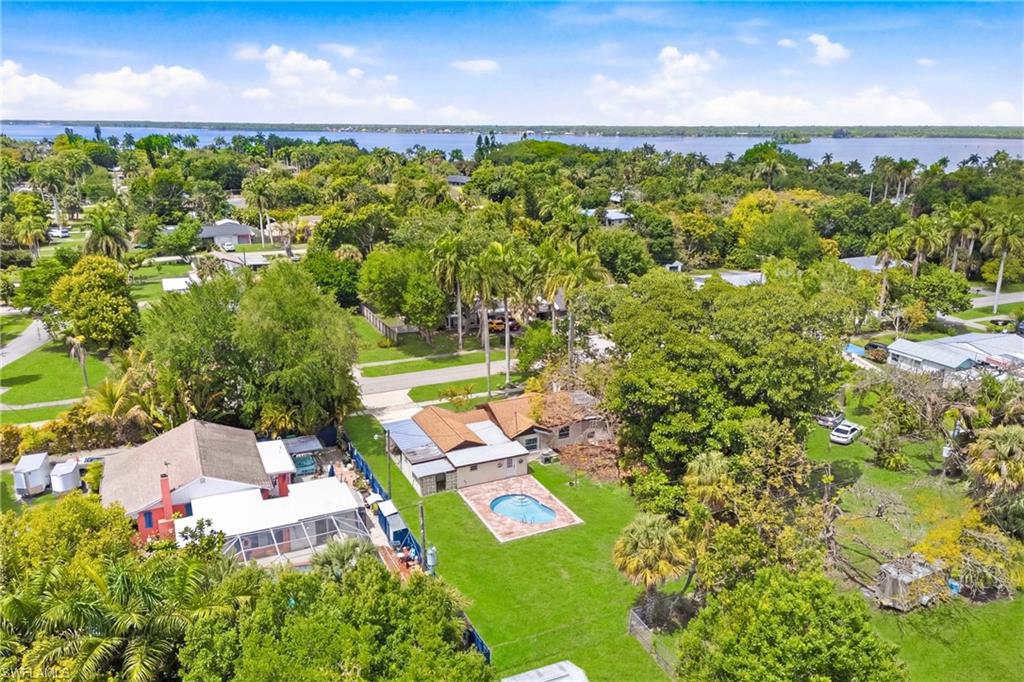 Beautiful aerial perspective showcasing the backyard pool, outdoor living space, and surrounding neighborhood.
