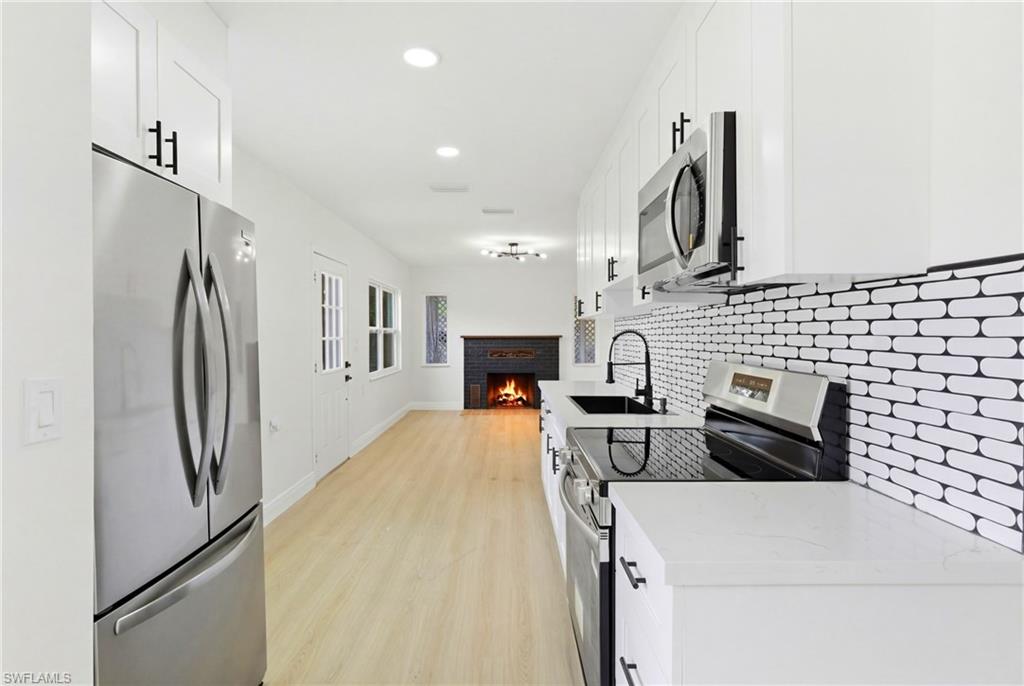 Bright and modern kitchen featuring classic subway tile backsplash paired with sleek stainless-steel appliances, offering a clean and timeless design.