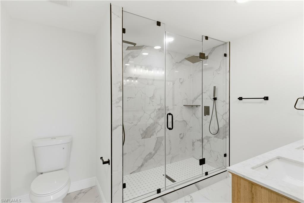 Beautifully updated primary bathroom featuring a spacious walk-in and modern finishes, creating a clean and luxurious spa-like feel.