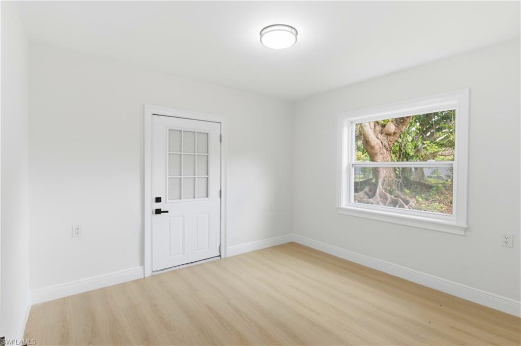Comfortable guest bedroom featuring a window and direct access door to the outdoors, offering convenience and natural light.