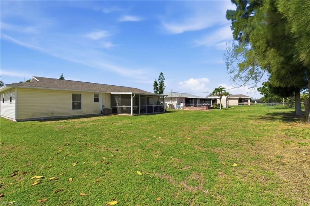 Back of house with a sunroom and a lawn