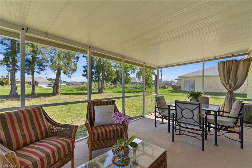 Sunroom / solarium featuring an outdoor living / dining area and a residential view