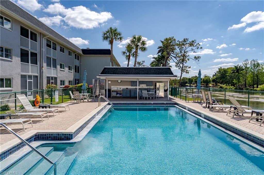 Pool featuring fence, a patio area, and outdoor dry bar