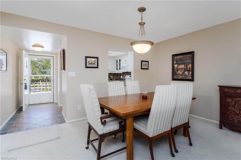 Dining room with baseboards and light colored carpet