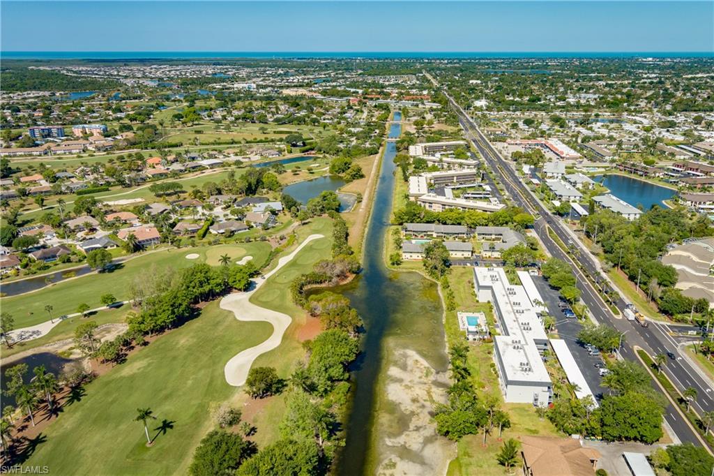 Birds eye view of property featuring view of golf course, a water view, and a residential view