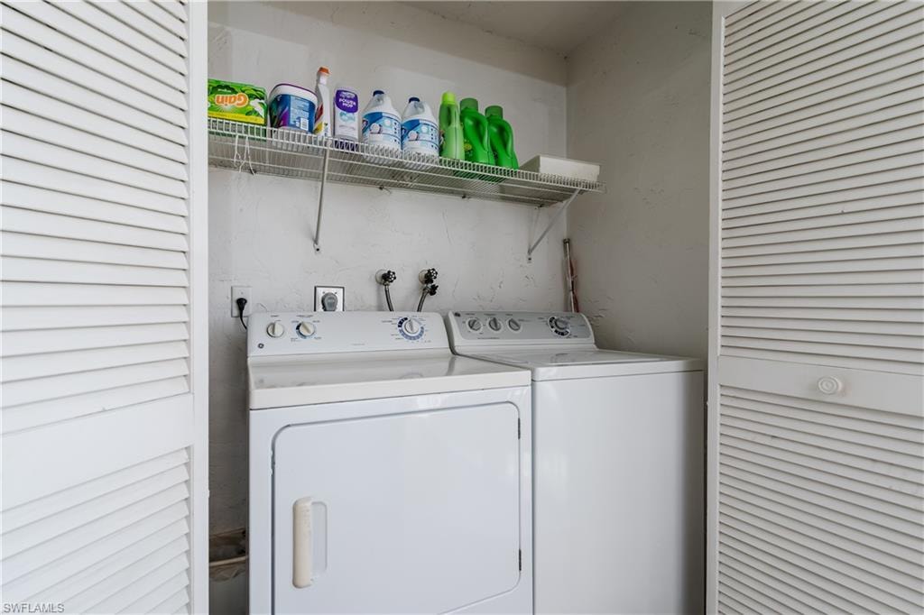 Washroom featuring laundry area and washer and clothes dryer