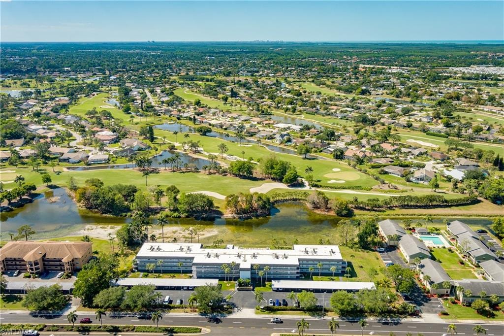 Drone / aerial view with view of golf course, a water view, and a residential view