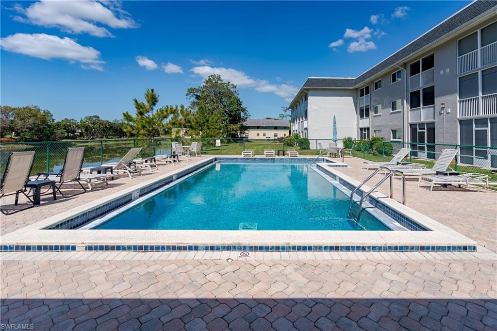 Pool with a patio and fence