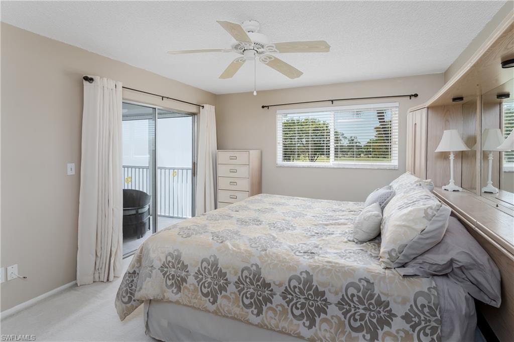 Carpeted bedroom with ceiling fan, baseboards, and access to outside