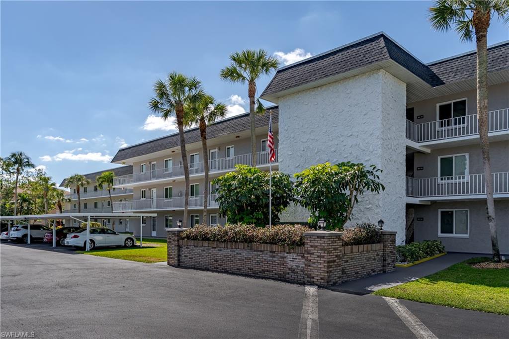 View of building exterior featuring covered parking