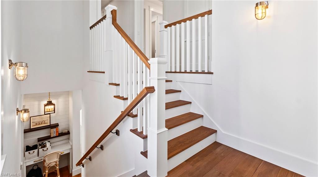 Stairway with wood finished floors and baseboards