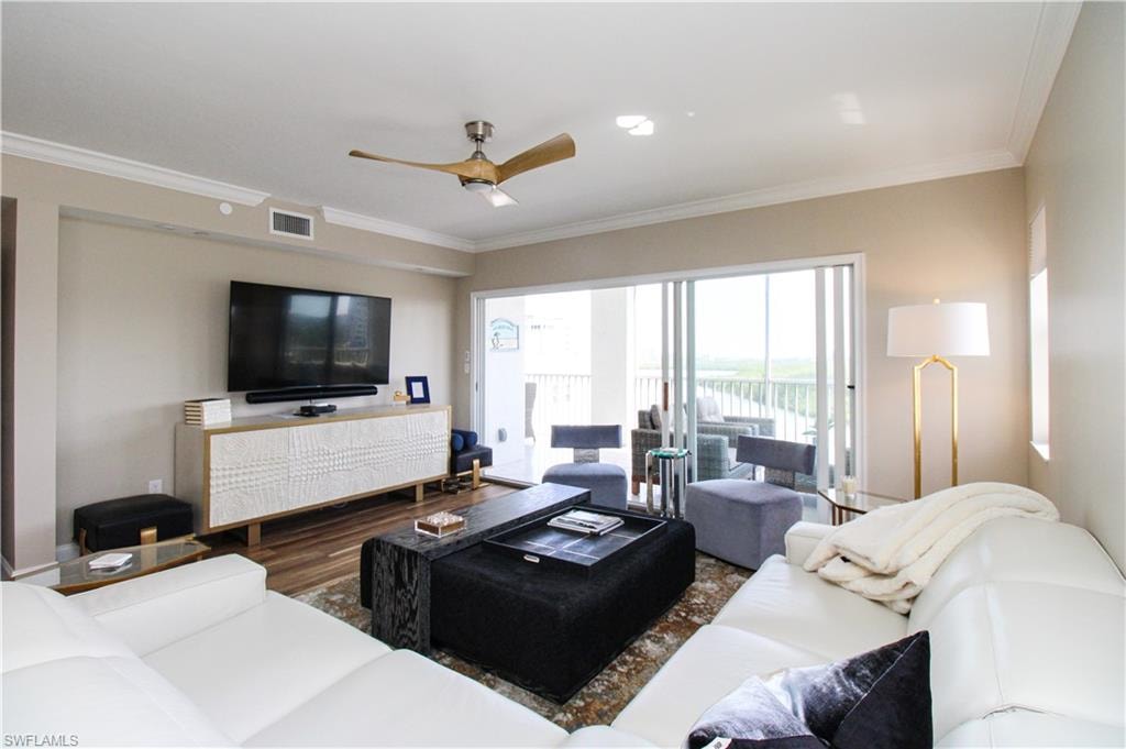 Living room with crown molding, hardwood / wood-style floors, and ceiling fan