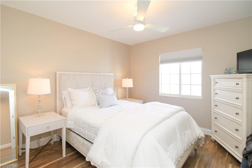 Bedroom with ceiling fan and dark hardwood / wood-style floors