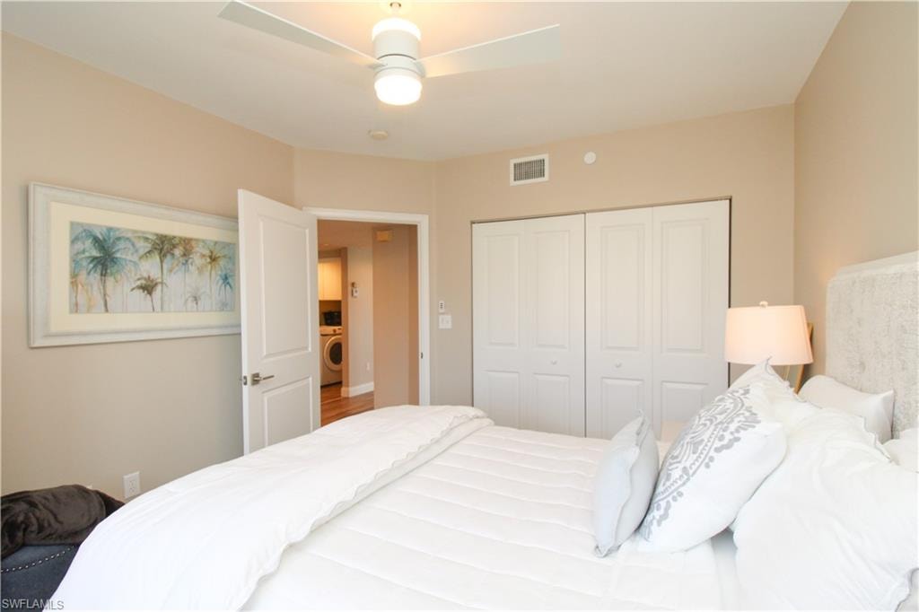Bedroom with a closet, ceiling fan, washer / dryer, and hardwood / wood-style floors