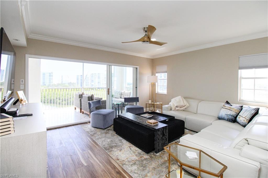 Living room with ornamental molding, hardwood / wood-style floors, and ceiling fan