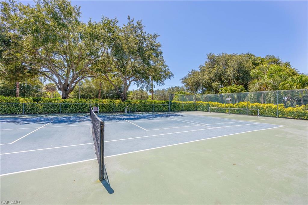 View of tennis court with fence and community basketball court