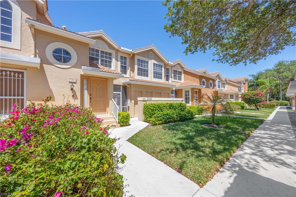 Townhome / multi-family property featuring stucco siding and a front lawn